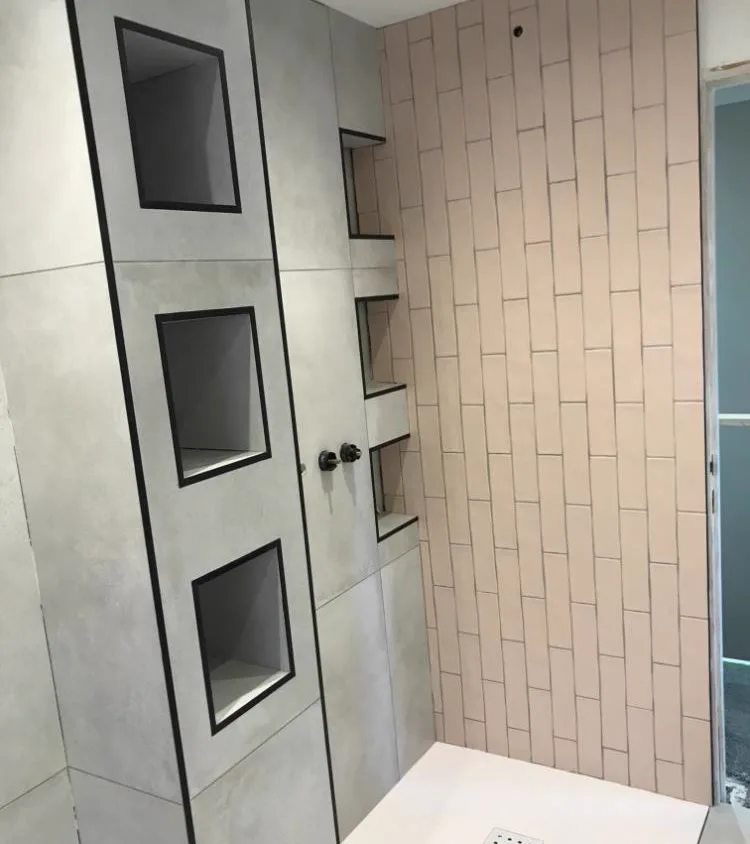 Grey large-format shower wall with recessed niches beside blush vertical metro tiles, Banks and Co Ceramics wet room installation